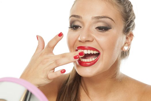 A young woman cleaning her teeth from lipstick
