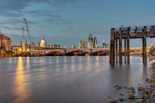 An old pier, the St Pauls cathedral, Blackfriars Bridge and the City of London