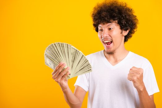 Asian handsome man with curly hair holding fans of money dollar 