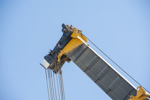 Large crane jib against blue sky background