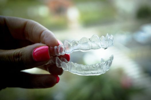 Invisible dental retainer held by womans hand