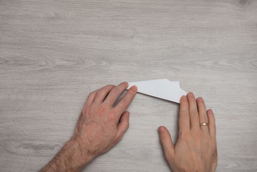 How to make origami paper airplane step by step photo instruction on wooden table with arms. Step 11