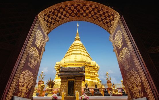 golden pagoda view through from ancient door architrave arch at Wat Phra That Doi Suthep temple. popular famous tourist temple attraction landmark in Chiangmai, Thailand