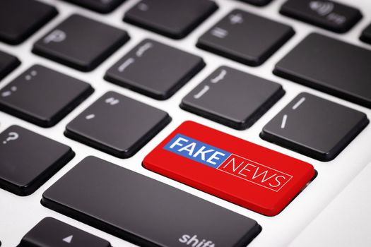 red fake news button on laptop keyboard. fake news on internet in modern digital age concept