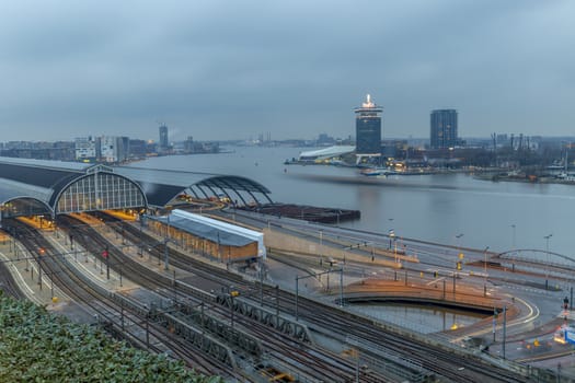 Aerial view of the train station at the edge of the big river in the late evening dull and rainy sky
