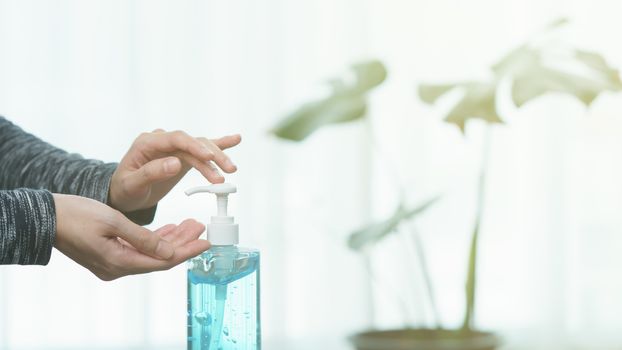 Woman cleaning her hands with sanitizer liquid antibacterial gel