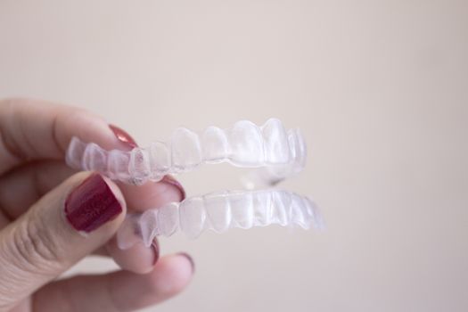 Invisible dental orthodontics held by a woman