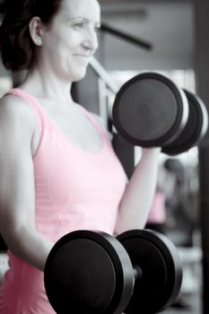 Thin thirties woman doing exercise in the gym