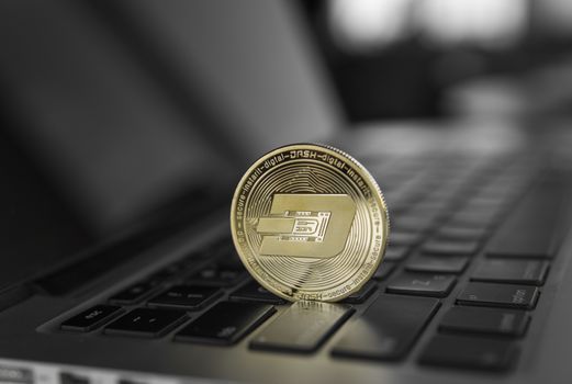 Gold Dash crypto coin on a laptop keyboard. Exchange, bussiness, commercial. Profit from mining crypt currencies. Miner with ethereum coin.