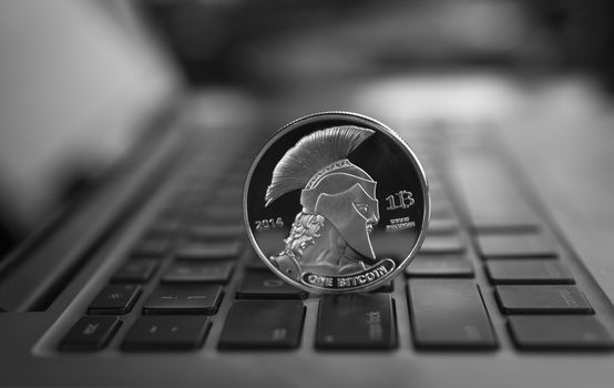 Silver Titan crypto coin on a laptop keyboard. Exchange, bussiness, commercial. Profit from mining crypt currencies. Miner with ethereum coin.