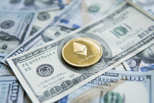 Gold Ethereum crypto currency on US dollars. Digital cryptocurrency close-up. Exchange, bussiness, commercial. Profit from mining crypt currencies. Miner with dollars and gold ethereum coin.