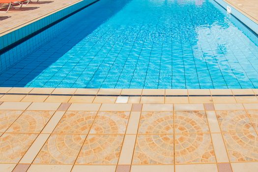 Swimming pool with nobody. vacation resort Outside empty pool with blue water. Outdoor pool property hotel relax exterior. poolside perspective photography with tile floor.  