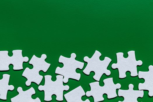 White jigsaw puzzle. White puzzle pieces on color background. Unfinished white jigsaw puzzle pieces on color background. 