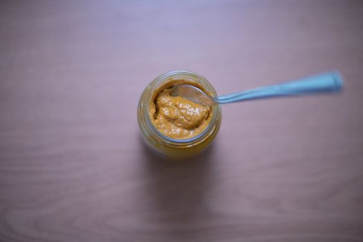 Selective focus of mustard jar with spoon