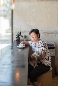 Asian women and dog so cute mixed breed with Shih-Tzu, Pomeranian and Poodle in coffee shop cafe