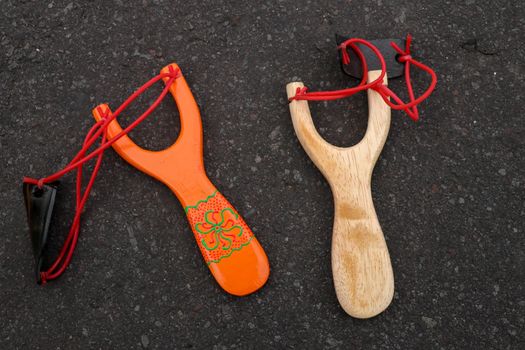 Couple of simple wooden slingshot isolated. Orange and natural w