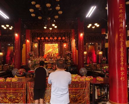 Two Men Pray at the Altar of a Temple in Taiwan