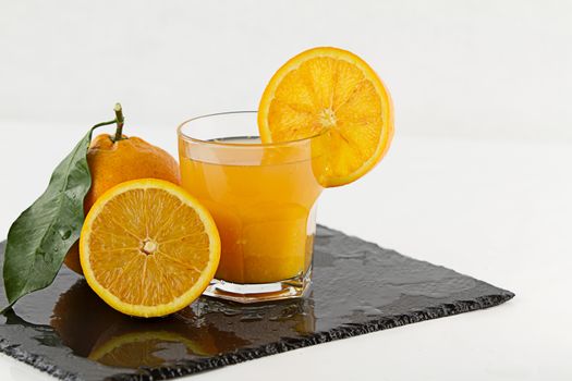 An inviting glass full of orange juice with orange slice on the 