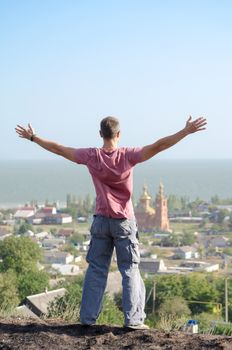young athletic man spread his arms over the cliff