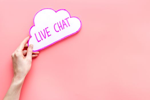 Live chat concept - bubble in hands on pink table top view