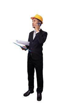 full portrait of Asian engineer man standing isolated on white background with clipping path. engineer with yellow safety helmet have blueprint in hand , holding paper file and using mobile phone