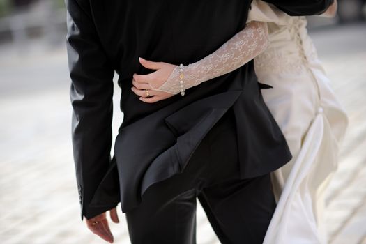 Bride girdling groom's waist