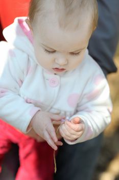Little girl touching hepatica flower