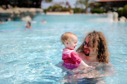 Young father and his baby girl in a pool