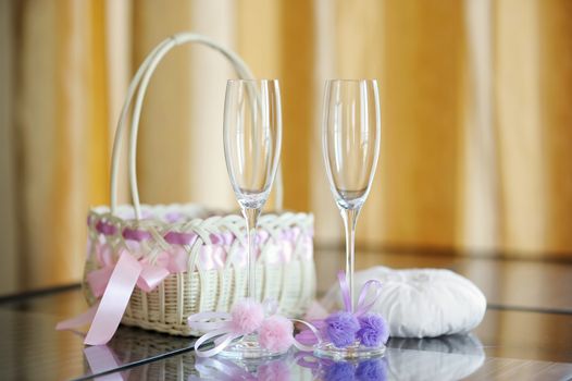 A pair of wedding glasses, basket and a ring pillow