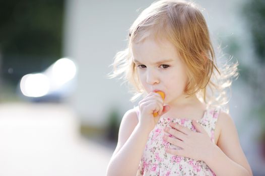 Adorable preschooler girl eating carrot