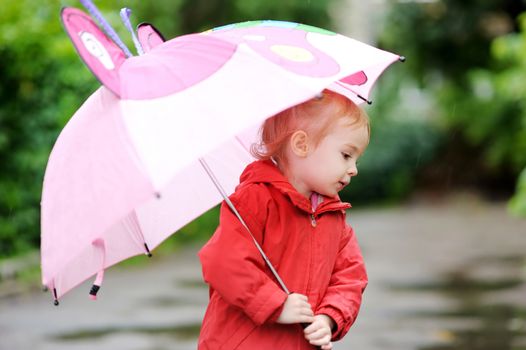 Adorable girl at rainy day in autumn