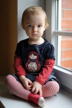 Two years old toddler girl by the window