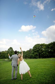 Bride and groom flying a kite