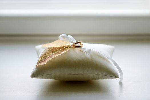 Two wedding rings on a pillow