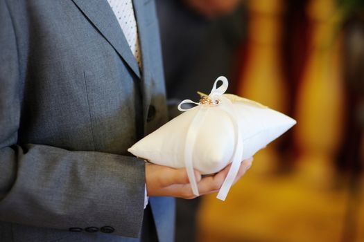 Child holding a pillow with the wedding rings