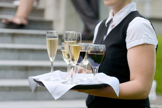 Waitress with dish of champagne glasses