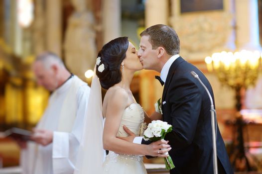 Bride and groom kissing in a church