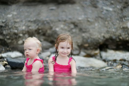 Two little sisters relaxing in hot spring