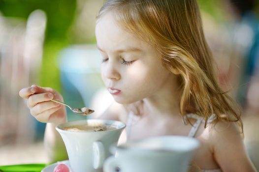 Adorable little girl drinking hot chocolate