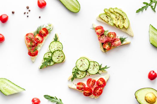 set of avocado sandwiches on white background top-down pattern