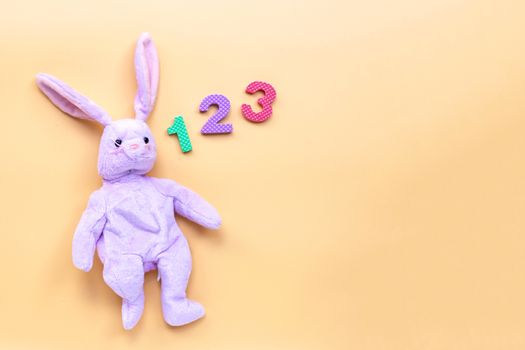 Rabbit toy with  numerals on yellow background. Education concep