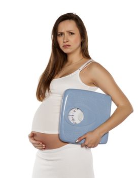 happy pregnant woman holding the scales