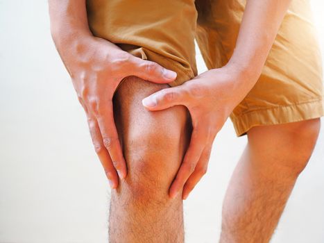 Young man suffering osteoarthritis knee pain, Body and leg pain