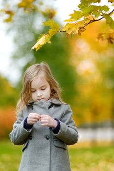 Adorable little girl having fun on autumn day