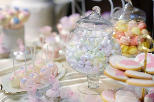 Decorated colorful candies on a pink table