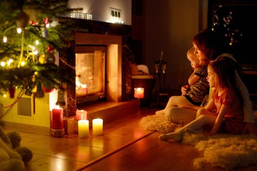 Happy family by a fireplace on Christmas