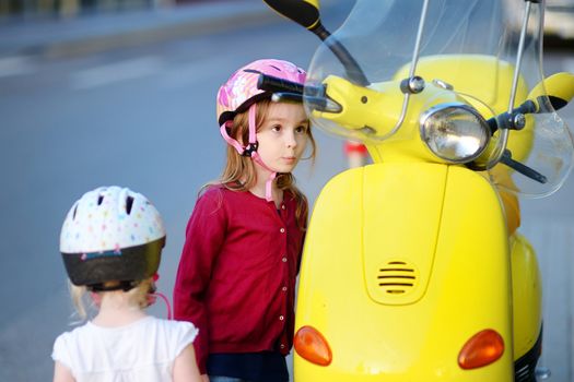 Two very curious little girls and a motorcycle