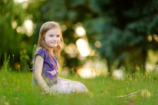 Cute little girl sitting on the grass