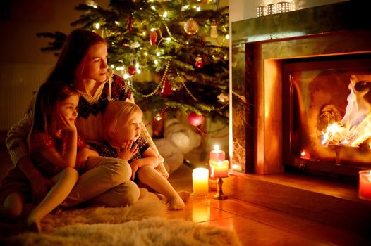 Happy family by a fireplace on Christmas
