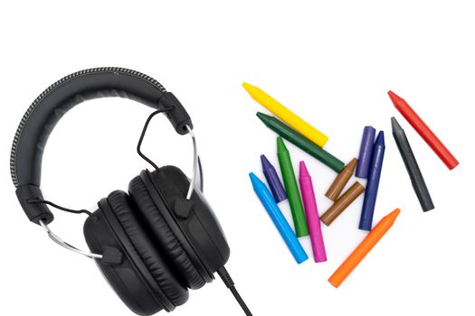 Headphones and 12 colored pencils on a white background